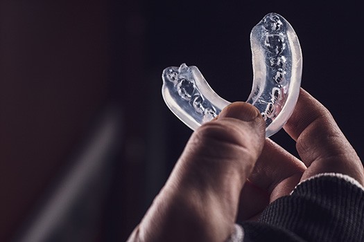 Patient holding clear mouthguard