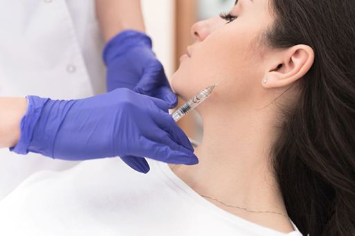 Woman receiving BOTOX injection near her TMJ