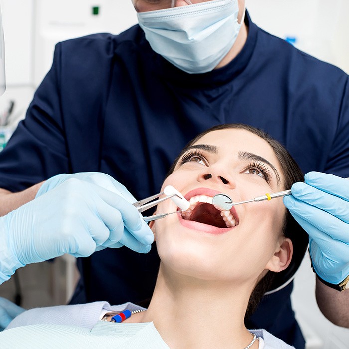 A dental team performing a dental checkup on a woman