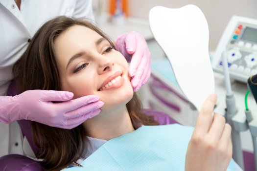 A woman admiring the results of her cosmetic dental work