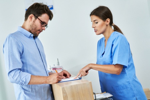 A man paying the cost of cosmetic dentistry