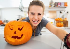 Laughing woman with a carved pumpkin 